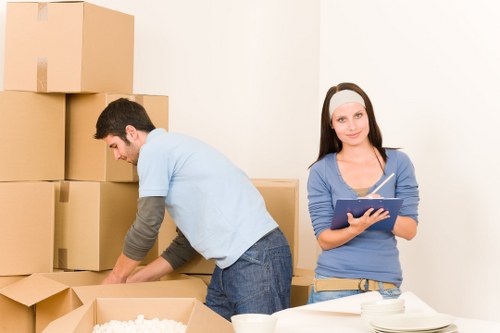 Packed household storage in Stgiles with labeled boxes and covered furniture